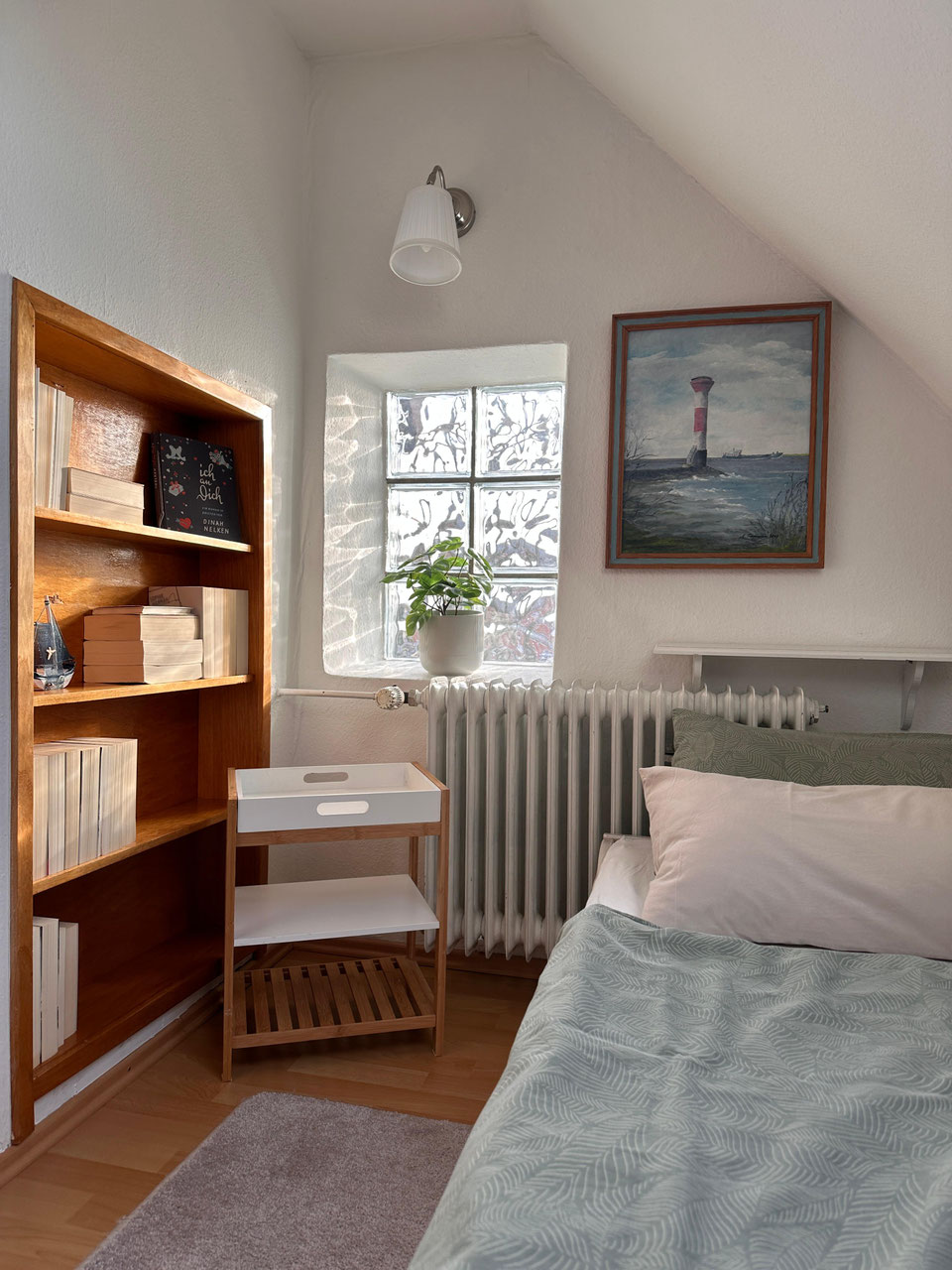 Einzelzimmer mit Bett und Bücherregal